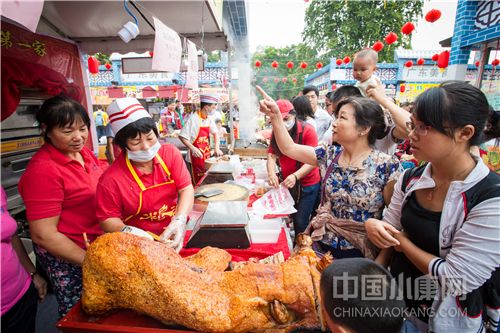 2015年10月31日，广东佛山，佛山美食节在顺德区北滘镇北滘广场举行，活动现场一摊位前几位市民排队购买顺德传统美食烧猪.jpg