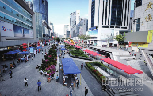 2 月 24 日， 在深圳华强北的步行街上， 商户、客户和物流人员在室外忙碌
